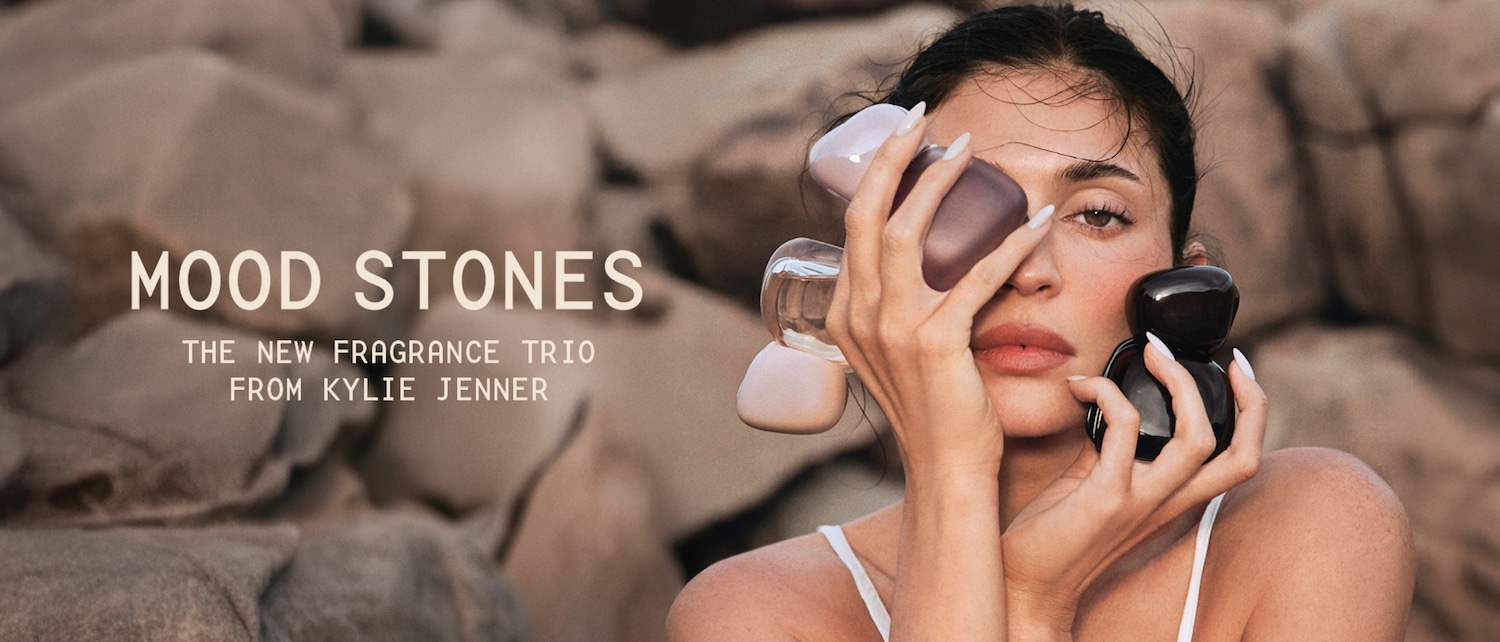 Kylie Jenner posa con tres frascos de perfume de formas orgánicas en tonos beige, rosa y marrón mientras se presenta el trío de fragancias Mood Stones; descúbrelas ahora.